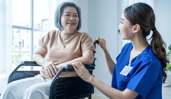asian nurse take care senior woman on wheelchair at nursing home care